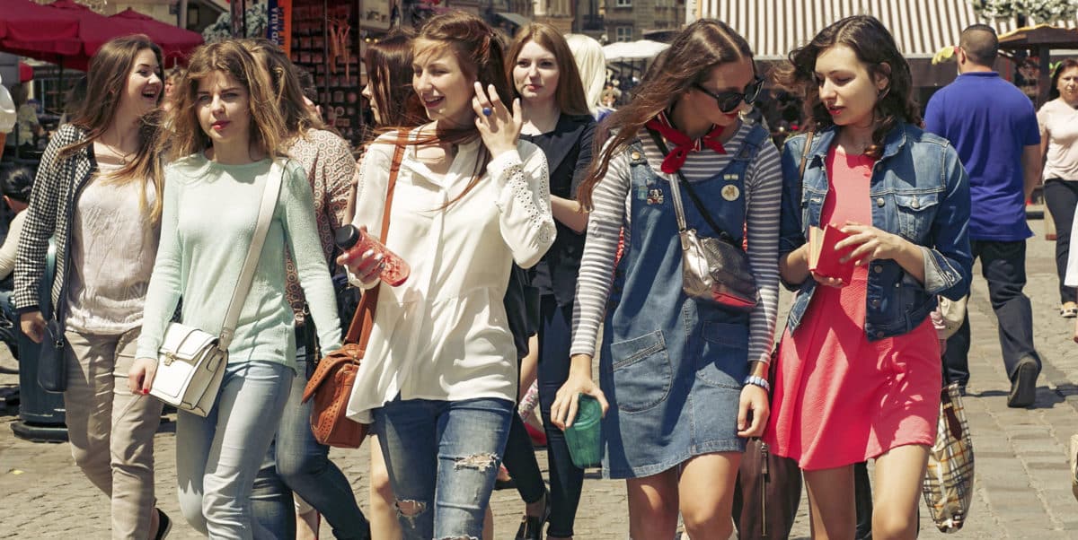 many young happy women walking talking on background of old eur