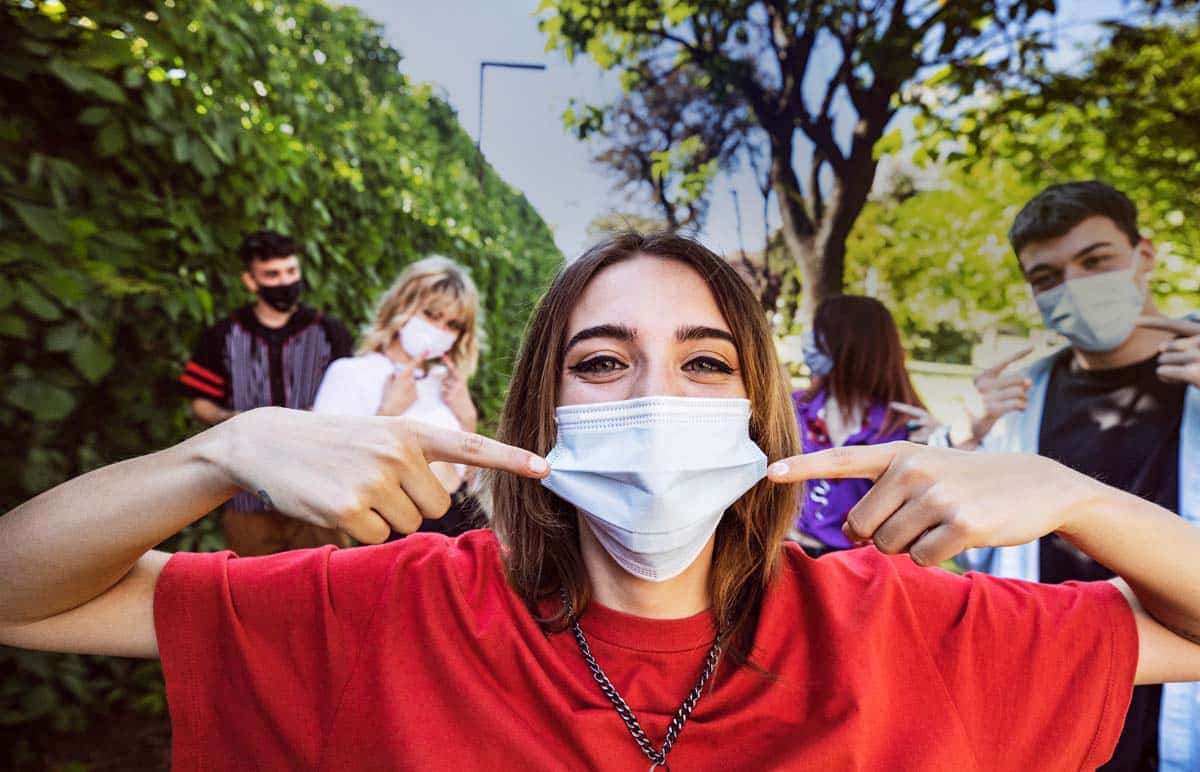 Group of teenagers posing showing their protective face masks