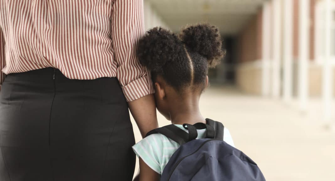Elementary, African American girl with mom on first day of school.