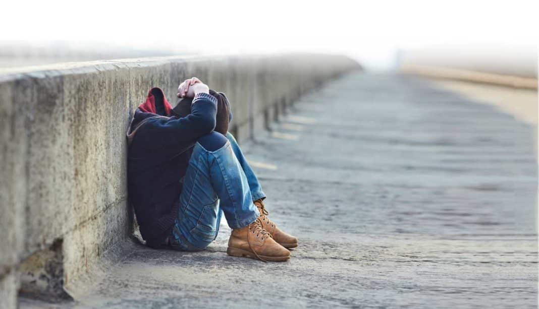 young homeless boy sleeping on the bridge