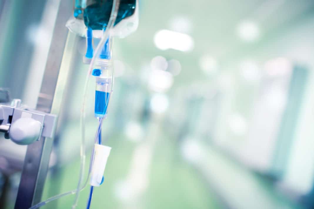 Blue intravenous drip in the hospital foyer as a concept of assi